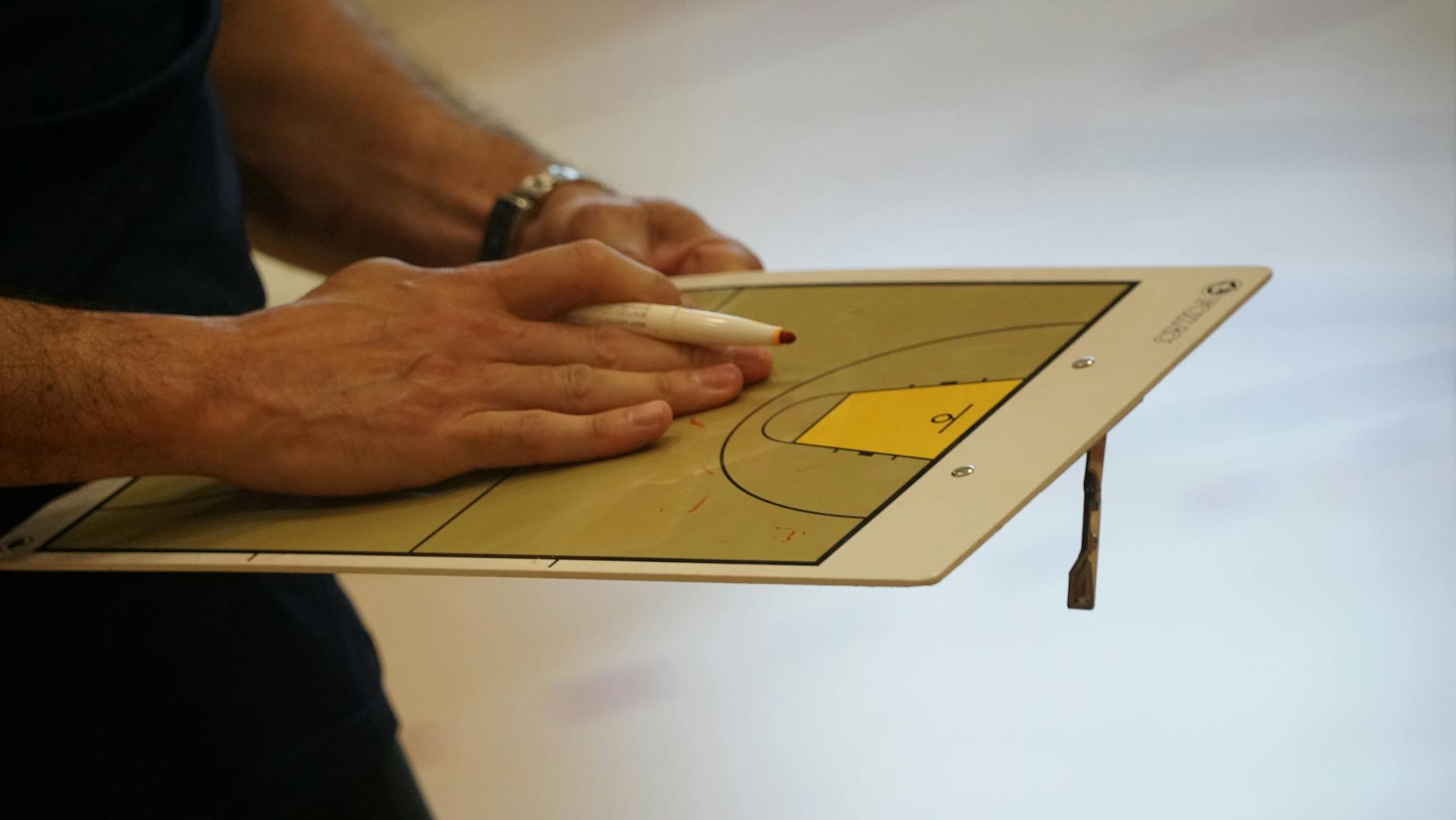 Młody bokser z Gniezna świętujący swój sukces na krajowym podium, obok symboliczne przedstawienie planów finansowych miasta.